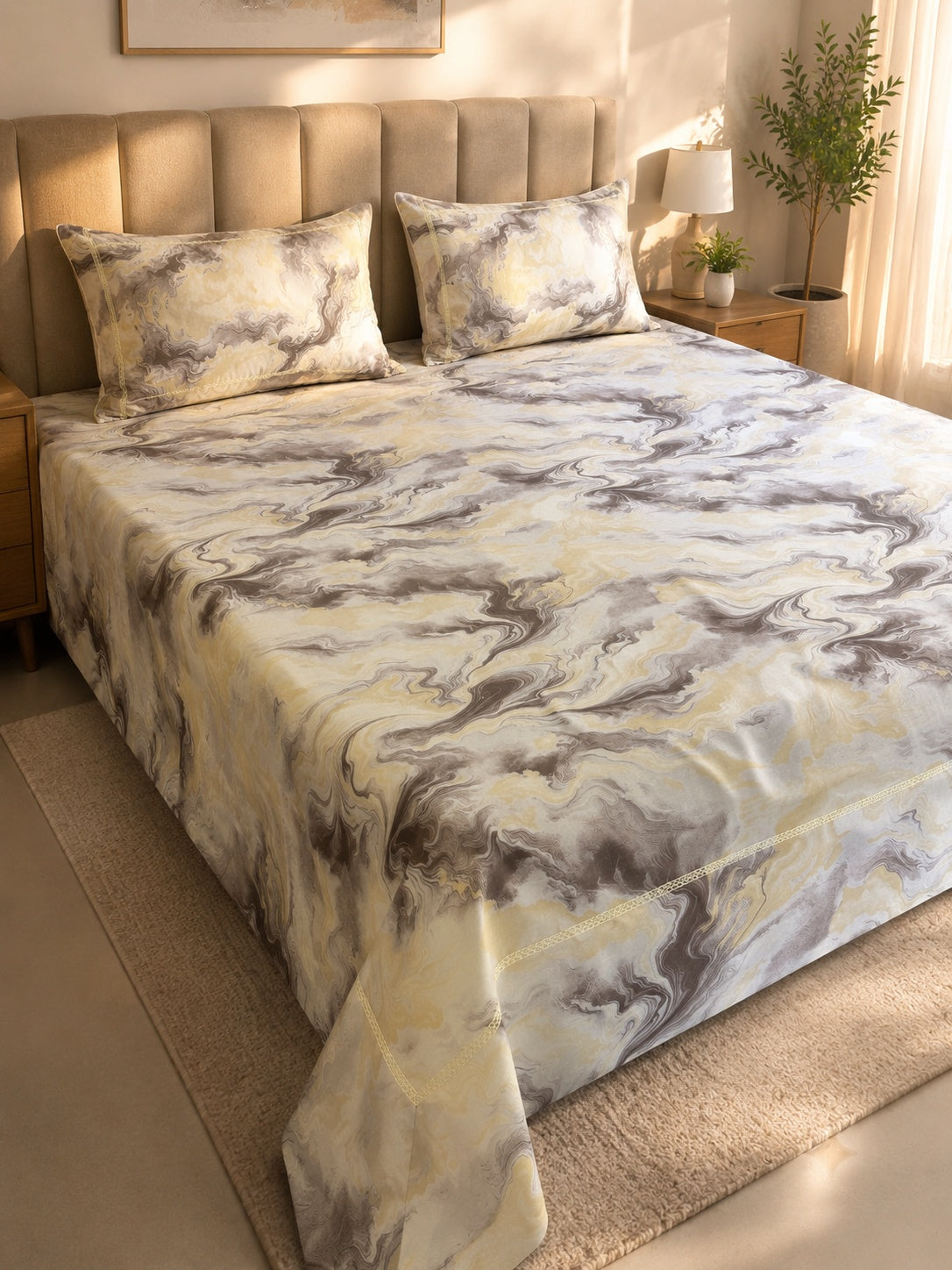 A marble-patterned bedding set with a cream, beige, and gray swirl design, styled on a bed in a warm, modern bedroom setting.