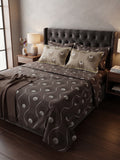 A bed dressed in a dark brown and beige patterned bedding set, featuring a tufted dark gray headboard, wooden nightstands, and warm bedside lighting in a styled bedroom setting.