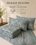 A bedding set displayed on a bed with a folded bedsheet and two patterned pillow covers. The set features a blue and green floral/medallion print on a light beige background.