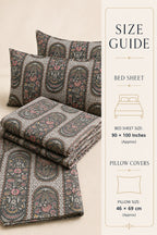 A bedding set with a detailed paisley and floral pattern in muted gray, pink, and green tones, shown folded and with two pillowcases on the left, next to a vertical size guide panel on the right detailing measurements for a bed sheet and pillow covers.
